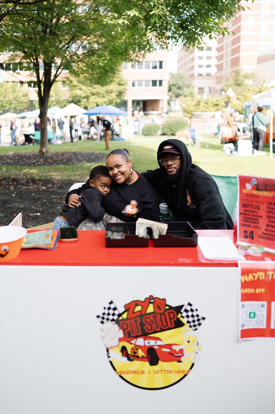 A kid pouring lemonade for a customer at a booth